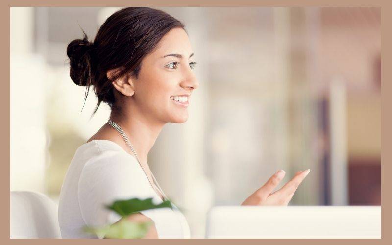 Femme coach souriante symbolisant la synergie entre stratégie et mindset pour une activité qui se développe.