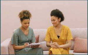 Deux femmes souriantes échangeant, symbolisant la connexion humaine et la confiance pour convertir des clients.